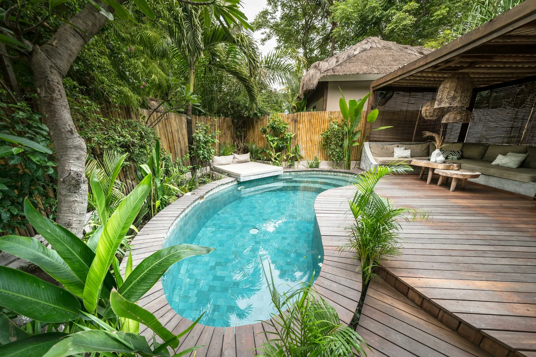 A sunlit tropical villa with a private pool and open-air lounge